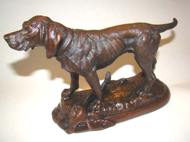 A fine late 19th century solid bronze sculpture of a hunting dog with his pheasant